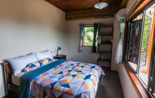 a bedroom with a bed and a window at Shenanigans Glamping Resort in Zamboanguita