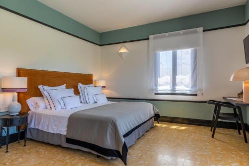 a hotel room with a bed and a window at Hoposa Cultural Boutique in Port de Pollensa
