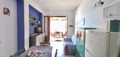 a small kitchen with a table and a refrigerator at Casa vacanze Lipari da Sergio spiaggia sotto casa in Lipari