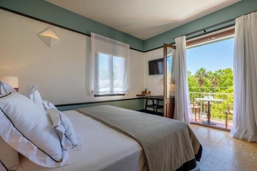 a bedroom with a bed and a view of a patio at Hoposa Cultural Boutique in Port de Pollensa