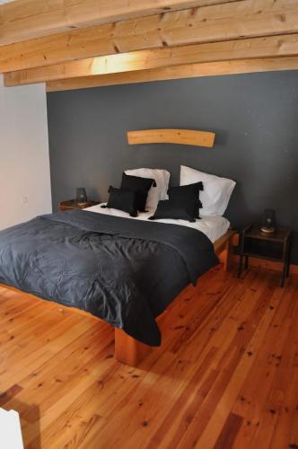 a bedroom with a bed with black and white pillows at Les Antonins in Marville