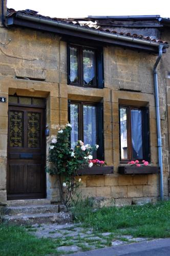 a brick house with a door and windows and flowers at Les Antonins in Marville
