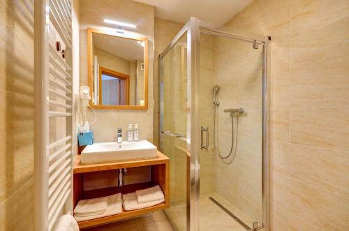 La salle de bains est pourvue d'un lavabo et d'une douche. dans l'établissement Chalet Nova Lesna Mountain View, à Nová Lesná