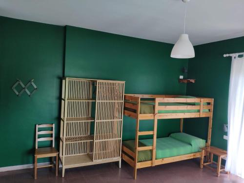 a green room with a bunk bed and two chairs at B&B De Angelis in Ginosa Marina