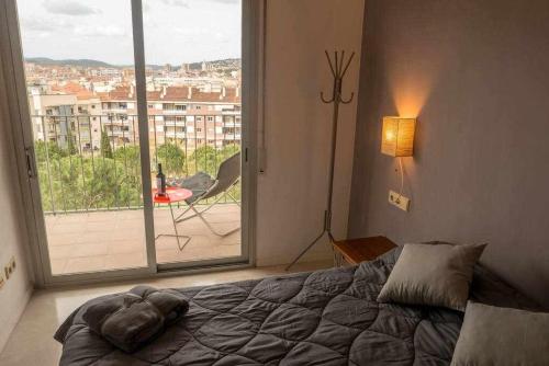 ジローナにあるApartamento con terraza y parking privado Gironaのベッドルーム1室(ベッド1台、大きな窓付)