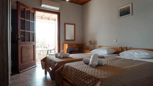 a bedroom with two beds with towels on them at SOULA ROOMS in Kini