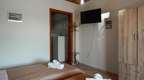a bedroom with a bed with two towels on it at SOULA ROOMS in Kini