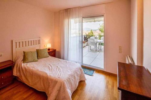 a bedroom with a bed and a view of a patio at Ático con gran terraza en el corazón de Girona in Girona