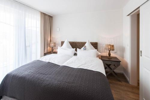1 dormitorio con 1 cama grande con almohadas blancas en Weisse Villa Apartment 2 4 Estelles Beachhouse en Büsum