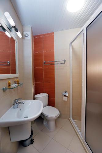 a bathroom with a toilet and a sink and a shower at Корал, Хотел, Поморие in Pomorie