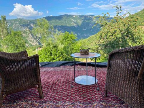 a patio with two chairs and a table on a rug at Cottage Modrich in Struga