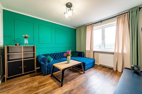 a living room with green walls and a blue couch at Apartament z Widokiem in Mikołajki