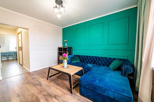 uma sala de estar com um sofá azul e uma mesa em Apartament z Widokiem em Mikolajki