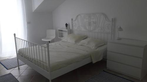 a white bedroom with a white bed and a dresser at Apartment with a sea view in Skiper resort in Crveni Vrh