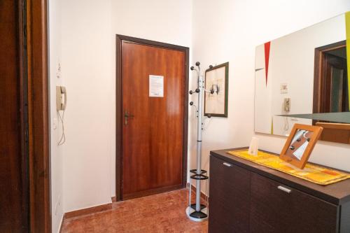 a bathroom with a wooden door and a counter with a mirror at [PIETRA LIGURE] The apartment for your vacations. in Pietra Ligure