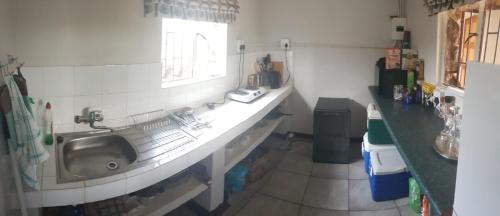 a small kitchen with a sink and a window at Croc Lapa Chalet in Malelane