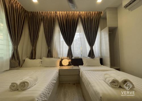 zwei Betten neben einem Fenster mit Handtüchern drauf in der Unterkunft Ipoh Mansion House 21 by Verve (14pax) EECH74 in Ipoh