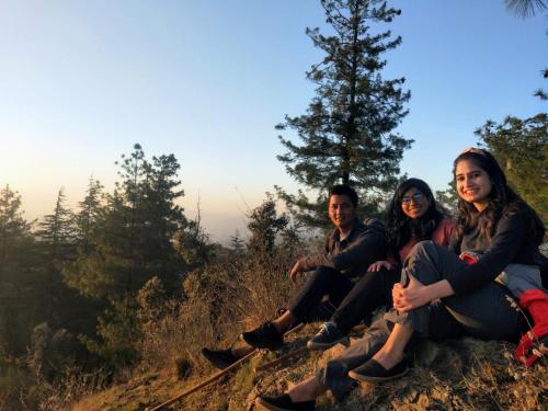 a group of people sitting on top of a hill at Neha Homestay in Shimla