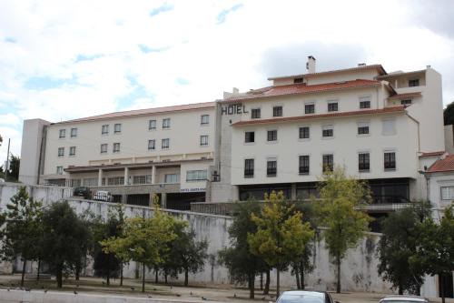 a white building with trees in front of it at Hotel Santa Maria in Alcobaça