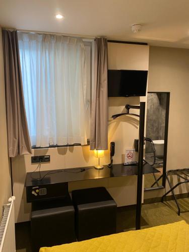 een kamer met een bank en een bureau met een raam bij Cityview Hotel in Amsterdam