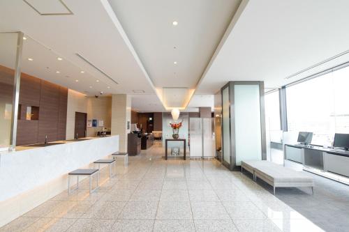 a lobby of a building with benches and a counter at Via Inn Okayama in Okayama
