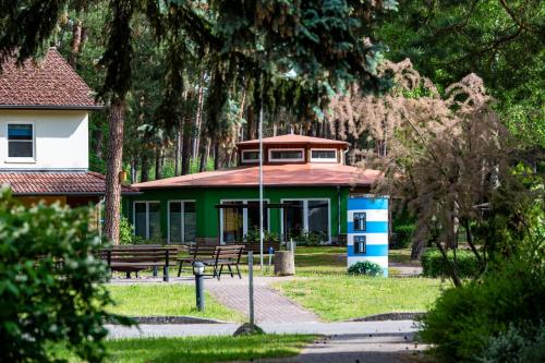 a building with benches in a park with trees at IDA Arendsee in Arendsee