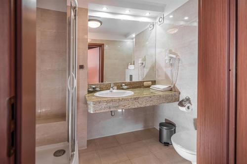 a bathroom with a sink and a toilet at Hotel Rigga in Władysławowo
