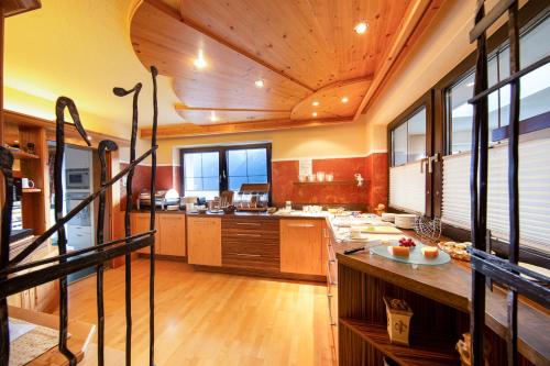 a large kitchen with wooden floors and a wooden ceiling at Haus Stefanie in Sölden