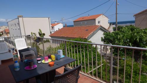 d'un balcon avec une table et des chaises sur une clôture. dans l'établissement Coquet duplex de 6 couchages, vue mer !, à Narbonne-Plage
