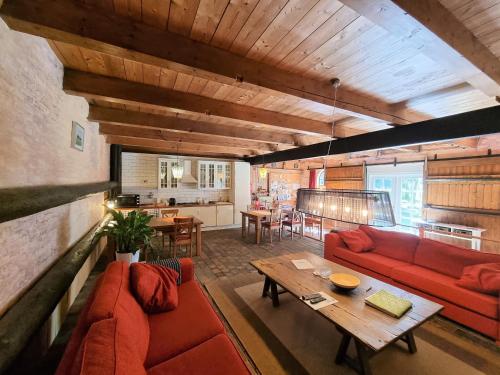 a living room with red couches and a wooden table at B&B de Hugt in Ulrum