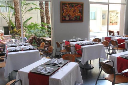 a restaurant with tables with red and white table settings at Casablanca Suites & Spa in Casablanca