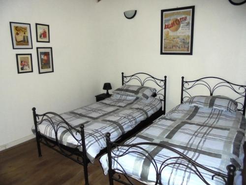 - 2 lits jumeaux dans une chambre avec des photos sur le mur dans l'établissement La Coquille Cottage, à Pillac