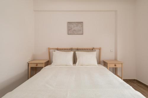 a bedroom with a bed with two wooden tables at My Oneiro City Apartments in Ioannina
