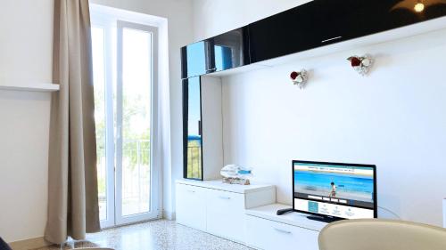 un soggiorno bianco con TV e finestra di Casa Gioia (2) - Le Ghiaie a Portoferraio