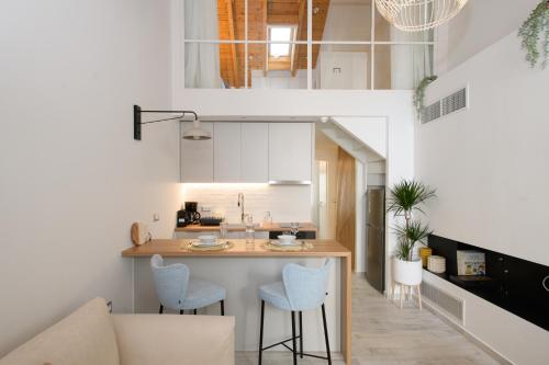 een keuken met een aanrecht en stoelen in een kamer bij Pilos Sunrise Loft in Pylos