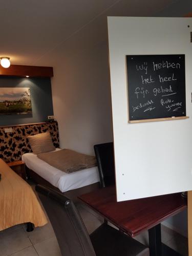 a room with two beds and a chalkboard on the wall at Boerderij Hazenveld in Kockengen