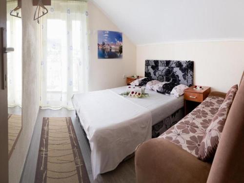 a bedroom with a bed and a couch and a window at Apartment Ana-Marija in Trebinje