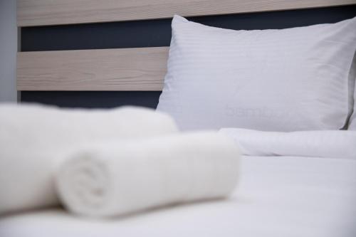 a white bed with white pillows and a wooden headboard at SithoniaRS Luxury Apartment 2nd Floor with Sea View in Neos Marmaras