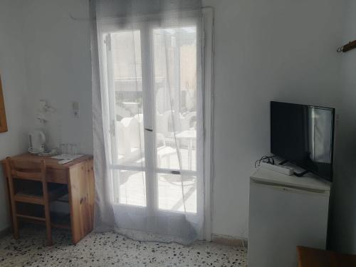 a living room with a door with a television and a table at Dilino in Kamari
