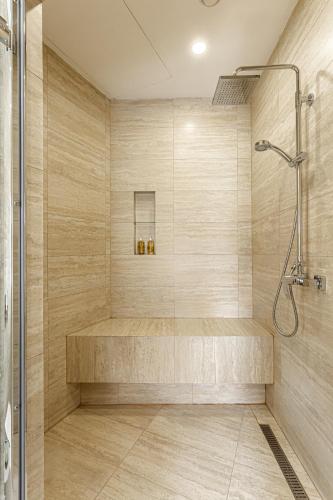 a bathroom with a shower with a bench in it at Senator Maidan in Kyiv