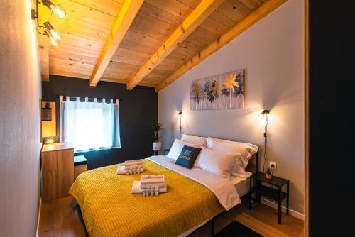a bedroom with a large bed with a yellow blanket at DreamStone Kolan in Kolan