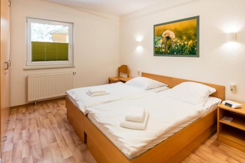 a bedroom with a large bed with white sheets at IDA Arendsee in Arendsee