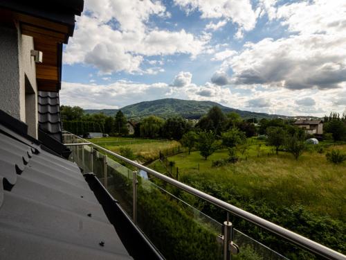 a balcony with a view of a field and mountains at Villa & Gospoda Krakowska in Kobiernice
