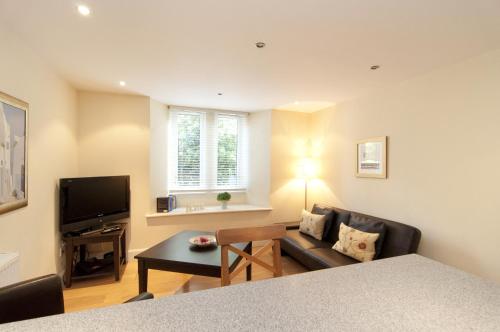 a living room with a couch and a television at Edinburgh Church Apartments in Edinburgh