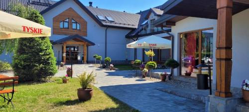 a group of buildings with plants in a yard at Villa & Gospoda Krakowska in Kobiernice