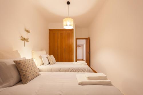 1 Schlafzimmer mit 2 Betten und einem Spiegel in der Unterkunft FLH Alfama Flat with River View in Lissabon