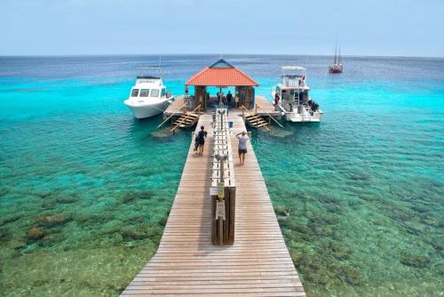 a dock in the water with boats in the water at Divi Flamingo Beach Resort in Kralendijk