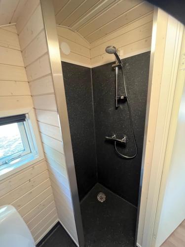 a bathroom with a shower in a tiny house at SportsPark Blaavandshuk Resort in Oksbøl