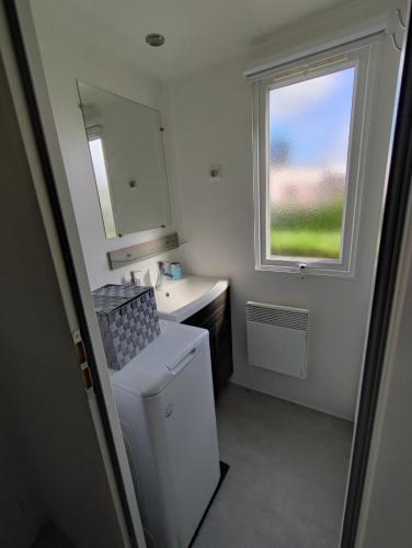 une petite salle de bain avec un lavabo et une fenêtre dans l'établissement mobilhome 741 Les Charmettes,3ch,2sdb,lave linge,lave vaisselle,clim,2wc, aux Mathes