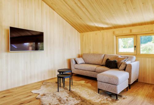ein Wohnzimmer mit einem Sofa und einem Stuhl in der Unterkunft PfänderGlück in Lochau